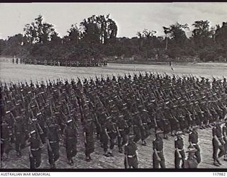 TOROKINA, BOUGAINVILLE. 1945-10-29. PERSONNEL OF 47TH INFANTRY BATTALION MOVING TOWARDS THE SALUTING BASE WHERE THE COMMANDER IN CHIEF, AUSTRALIAN MILITARY FORCES, IS TAKING THE SALUTE DURING A ..