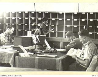 PORT MORESBY, PAPUA, NEW GUINEA. 1944-03-13. VX19861 SIGNALMAN K.J. MCDOWELL (1), AT THE DESPATCH RIDER LETTER SERVICE OFFICE, SORTING MAIL WITH MEMBERS OF THE 18TH LINES OF COMMUNICATION SIGNALS, ..