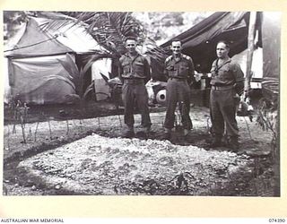 SIAR, NEW GUINEA. 1944-06-28. VX139884 CORPORAL A.M. JENKINS (1); VX89731 CORPORAL S.R. CHENERY (2); AND B3/99 MR W.A. ALVIN, SALVATION ARMY (3) ADMIRING THE NEW GARDEN SIGN MADE WITH CORAL OUTSIDE ..