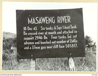 THE MASAWENG RIVER BATTLE SIGN MARKING THE CROSSING BY SIX TANKS FROM A SQUADRON, 1ST TANK BATTALION WHICH ATTACKED IN SUPPORT OF THE 29/46TH INFANTRY BATTALION. FOUR TANKS LEADING THE INFANTRY ..