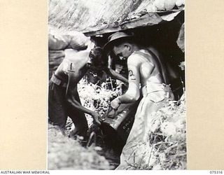 NAGADA, NEW GUINEA. 1944-08-16. V505385 GUNNER L.A. HISKINS (1) AND VX105756 BOMBARDIER D.L. MCCARTHY (2) OF E TROOP, 22ND BATTERY, 106TH TANK ATTACK REGIMENT PREPARING AMMUNITION FOR THEIR 6 ..