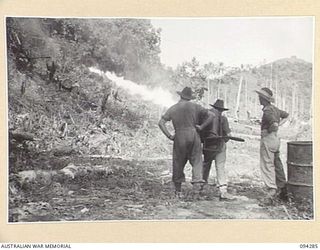 KARAWOP, NEW GUINEA. 1945-07-19. ONE OF THE STUDENTS AT 2/6 CAVALRY (COMMANDO) REGIMENT FIRING THICK FUEL FROM A FLAME-THROWER DURING ACTIVITIES AT THE FLAME-THROWER SCHOOL