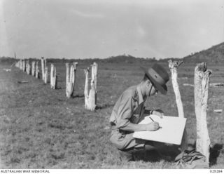 TOWNSVILLE, QLD. 1942-11. CAPTAIN J.C. MCALLESTER OF THE 2/14TH AUSTRALIAN INFANTRY BATTALION, ATTACHED TO 2/1ST MOBILE ANTI-GAS LABORATORY, PREPARING TARGETS FOR THE IMPROVISED RIFLE RANGE ON ..