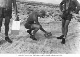 Scientists A.H. Seymour, A.D. Welander and Kellogg taking readings of radioactivity with Geiger counters on Enjebi Island, summer 1949