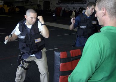 U.S. Navy CHIEF Aviation Ordnanceman Zachary A. MacDonald prepares to strike at CHIEF Aviation Structural Mechanic Christopher Carlson's"Red Man"bag during a boarding team training aboard the Tarawa Class Amphibious Assault Ship USS SAIPAN (LHA 2) in the Gulf of Aden on Sept. 11, 2006. SAIPAN is currently underway conducting maritime security operations in the Persian Gulf. (U.S. Navy photo by Mass Communication SPECIALIST Third Class Erik Siegel) (Released)