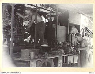 BOUGAINVILLE. 1945-08-30. STAFF SERGEANT KOETSVELD (1), OPERATING A POWER HACKSAW AND CRAFTSMAN N. BLIZZARD (2), OPERATING A LATHE INSTALLED ON A 3-TON TRUCK AT 2/4 ARMOURED REGIMENT WORKSHOP. THE ..