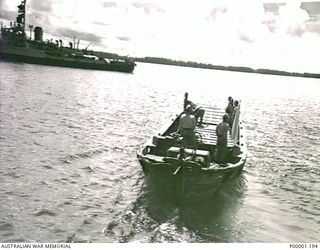 THE SOLOMON ISLANDS, 1945-08-20. JAPANESE BARGE, FLYING WHITE FLAG, LEAVING HMAS LITHGOW OFF MOILA POINT AFTER DELIVERING TWO JAPANESE OFFICERS TO BE ADVISED OF SURRENDER CONDITIONS AND ..