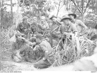 SATTELBERG AREA, NEW GUINEA. 1943-11-15. A PATROL FROM C COMPANY, 2/24TH AUSTRALIAN INFANTRY BATTALION, SETTING OUT TO TAP A JAPANESE TELEPHONE LINE, BEING BRIEFED BY THE OFFICER COMMANDING, C ..