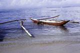 French Polynesia, children swimming by canoes off Moorea Island