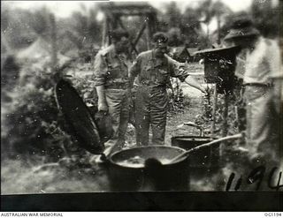 AITAPE, NORTH EAST NEW GUINEA. C. 1944-06. ARTHUR JOHN DEDMAN, THE MINISTER FOR WAR ORGANISATION OF INDUSTRY (CENTRE), WITH TWO RAAF OFFICERS INSPECTED THE OUTDOOR WASHING FACILITIES AT THE RAAF ..