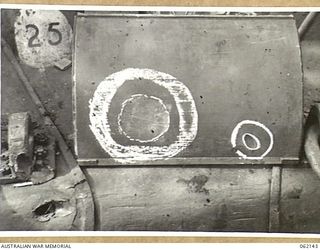 SCARLET BEACH AREA, NEW GUINEA. 1943-12-21. DRIVER'S COVER OF A MATILDA TANK SHOWING THE EFFECTS OF A JAPANESE MAGNETIC BOMB (LARGE CIRCLE) AND A 37MM SHELL (SMALL CIRCLE) AT THE 1ST AUSTRALIAN ..