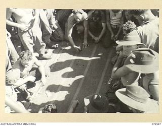 AT SEA. 1944-10-07. A DICE GAME IN PROGRESS ABOARD THE DUTCH TROOPSHIP "SWARTENHONDT" WHICH IS CARRYING TROOPS OF THE 36TH INFANTRY BATTALION FROM NEW GUINEA TO NEW BRITAIN