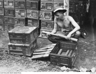 PORT MORESBY, NEW GUINEA. 1944-02-02. NX87243 SERGEANT R.J. GOUGH, UNPACKING 40MM BOFORS ANTI-AIRCRAFT AMMUNITION AT THE 8TH ADVANCED AMMUNITION DEPOT