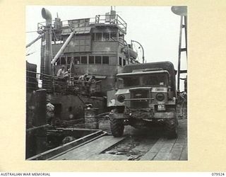 ORO BAY, NEW GUINEA. 1943-07. AN AMBULANCE FROM THE 10TH FIELD AMBULANCE WAITING ON THE WHARF TO TRANSFER PATIENTS TO THE UNIT MAIN DRESSING STATION FROM THE USS "KARU MARU"