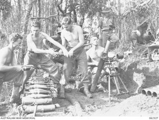 SHAGGY RIDGE, NEW GUINEA. 1943-12-27. MEMBERS OF A 3 INCH MORTAR CREW OF THE 2/16TH AUSTRALIAN INFANTRY BATTALION, 21ST AUSTRALIAN INFANTRY BRIGADE IN ACTION BOMBARDING THE "PIMPLE" PRIOR TO THE ..