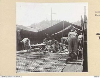 NANTAMBU, OPEN BAY, NEW BRITAIN, 1945-05. MEMBERS OF 36 INFANTRY BATTALION ABOARD A LANDING BARGE FROM 53 LANDING CRAFT COMPANY, WHICH BROUGHT HEAVY SUPPLIES FROM JACQUINOT BAY FOR 37/52 INFANTRY ..
