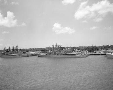 A port quarter view of Japanese destroyers and US ships moored to piers during Exercise RIMPAC '86