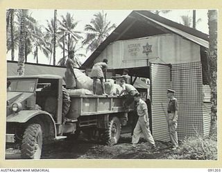 JACQUINOT BAY, NEW BRITAIN. 1945-04-27. A TRUCK LOAD OF MATTRESSES FOR DISTRIBUTION TO CASUALTY CLEARING STATIONS AND HOSPITALS BEING CHECKED BY CAPTAIN PARKER, COMFORTS FUND COMMISSIONER, AT 5 ..