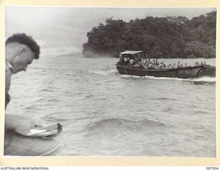 BOUGAINVILLE. 1945-10-01. LIEUTENANT R. W. W. ROWED, OFFICIAL WAR ARTIST, SKETCHING A JAPANESE BARGE LOADED WITH TROOPS AND STORES EN ROUTE TO A CONCENTRATION AREA IN THE FAURO ISLANDS