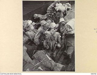 KAIRIRU ISLAND, NEW GUINEA. 1945-09-17. JAPANESE NAVAL PERSONNEL BEING TRANSFERRED TO MUSCHU ISLAND, STACKING THEIR GEAR ON THE DECK OF THE BARGE. FOLLOWING THE SURRENDER OF THE JAPANESE THE ..