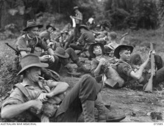 Wewak Area, New Guinea. 1944-05-26. A platoon of the 35th Infantry Battalion, Australian Military Forces, resting at Harinap during the drive along the coast to Wewak. Identified personnel are ..