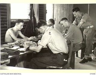 MEMBERS OF THE POSTAL UNIT, 2/1ST AUSTRALIAN GENERAL HOSPITAL SORTING MAIL. IDENTIFIED PERSONNEL ARE:- PRIVATE H. THOMSON (2); PRIVATE J. SMITH (3); PRIVATE HAIG (4); CORPORAL H. SHORT (5)