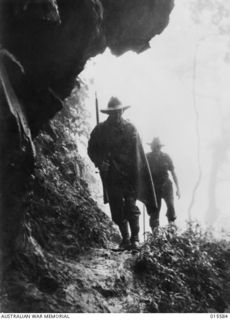 1943-08-19. NEW GUINEA. MOUNT TAMBU. LT. STAN CONDON, A.I.F. OF MUDGEE, N.S.W., WOUNDED IN THE MOUNT TAMBU FIGHTING, RETURNING FROM THE FRONT LINE TO AN ADVANCED DRESSING STATION. WHILST HE WAS ..