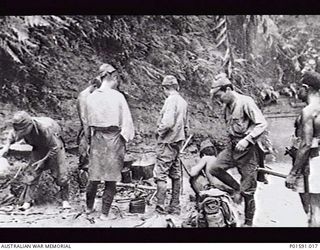 PRINCE ALEXANDER RANGES, NEW GUINEA. 1945-08. A NATIVE OFFICER WITH JAPANESE PRISONERS OF WAR. A TOTAL OF FORTY-TWO PRISONERS WERE TAKEN AT THIS TIME BY MEMBERS OF THE 2/7TH BATTALION WITH THE ..