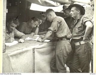 KILIGIA, NEW GUINEA. 1944-04-10. UNIT REPRESENTATIVES MAKING PURCHASES FROM THE CANTEEN ISSUING POINT 27E OPERATED BY THE AUSTRALIAN ARMY CANTEENS SERVICE. ABOUT 2,000 POUNDS EACH DAY IS SPENT AT ..