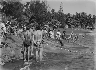 [Pacific Island people fishing with net on beach]