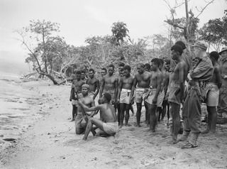 TOL AREA, NEW BRITAIN. 1945-08-02. NATIVE SOLDIERS OF ALLIED INTELLIGENCE BUREAU AT GENERAL TRAINING ON THE BEACH. THEY ARE USING RIFLES TO DISCHARGE GRENADES