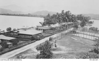 SALAMAUA, NEW GUINEA, 1940-02-?. A VIEW OF THE MAIN STREET ON THE PENINSULA. ON THE LEFT ARE THE HOTEL, BURNS PHILP STORE, CARGO SHED. ON THE RIGHT ARE TWO TENNIS COURTS, LATER THE SITE OF TENTS ..