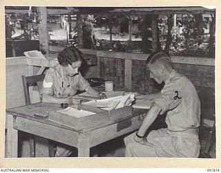 LAE, NEW GUINEA. 1945-05-15. PRIVATE L.T. TOOHEY (2), CHECKING WEEKLY REPORTS WITH SERGEANT N. GOLDENSTEDT (1), DURING STAFF DUTIES AT HEADQUARTERS FIRST ARMY. A FEW DAYS AFTER THEIR ARRIVAL FROM ..