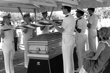 Pallbearers fold the flag during the funeral of Lieutenant Junior Grade (LTJG) Richard C. Sather at the National Memorial Cemetery of the Pacific. Sather was one of the first American pilots killed in North Vietnam in 1964. His remains were among 26 bodies of servicemen returned to the United States in August 1985 for burial
