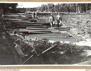 FINSCHHAFEN AREA, NEW GUINEA. 1943-11-09. SHEET METAL STRIPS STACKED AT THE SIDE OF THE NEW AIRSTRIP IN READINESS FOR LAYING BY THE ENGINEERS OF THE 808TH UNITED STATES ENGINEER AVIATION BATTALION ..