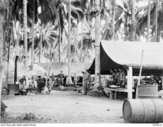 MATUPI, NEW GUINEA. 1944-07-04. PERSONNEL OF THE 15TH FIELD AMBULANCE WORKING IN THE KITCHEN AREA OF THEIR CAMP. IDENTIFIED PERSONNEL ARE:- VX145890 PRIVATE E.F. WATT (1); VX115989 CORPORAL A. ..