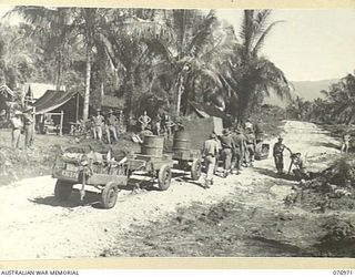 JACQUINOT BAY, NEW BRITAIN. 1944-11-17. TRACTOR AND TRAILERS TRANSPORTING A HEAVY LOAD OF SUPPLIES TO THE CAMP SITE OF THE 14/32ND INFANTRY BATTALION