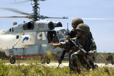 US Navy (USN) Sailors assigned to Mobile Security Squadron 7 (MSS-7), armed with 5.56 mm M4 carbines, equipped with blank firing devices, provide security for the Russian Federated Navy (RFN) KA-27 Helix helicopter as it lands at Santa Rita Naval Base, Guam (GU), during a joint humanitarian assistance, disaster relief exercise. RFN ships are participating in Passing Exercise 2006 (PASSEX 06) with USN ships off the coast of Guam. The Exercise is designed to increase interoperability between the two navies while enhancing the strong cooperative relationship between Russia and the US