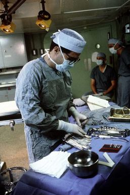 A hospital corpsman organizes surgical instruments for an operation aboard the amphibious assault ship USS SAIPAN (LHA-2)