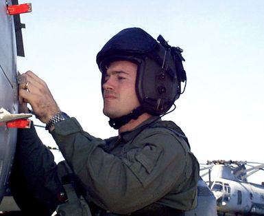 Marine Corps CPT Robert Kimbrell attached to Helicopter Medium Squadron Two Six Three (HMM-263) of the 24th Marine Expeditionary Unit (MEU) checks his AH-1 Cobra helicopter before flight operations from the amphibious assault ship USS GUAM (LPH 9). GUAM is deployed to the Persian Gulf in support of Operation Southern Watch