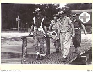 BOUGAINVILLE, 1945-06-18. MEMBERS OF 1 WATER AMBULANCE CONVOY, CARRYING A STRETCHER CASE ALONG A JETTY TO A WAITING BOAT, DURING THE EVACUATION OF WOUNDED BY WATER FROM MOTUPENA POINT, GAZELLE ..