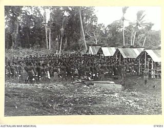 MALAMAL, NEW GUINEA. 1944-07-13. NATIVES LINED UP AT THEIR EVENING MEAL PARADE AT THE AUSTRALIAN NEW GUINEA ADMINISTRATIVE UNIT NATIVE LABOUR COMPOUND