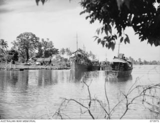 ALEXISHAFEN, NEW GUINEA. 1944-06-10. TWO HMA MOTOR LAUNCHES ALONGSIDE THEIR MOTHER SHIP HMAS KOOPA (LEFT) AT THEIR BASE IN THE HARBOUR. IN THE FOREGROUND IS THE HARBOUR DEFENCE MOTOR LAUNCH