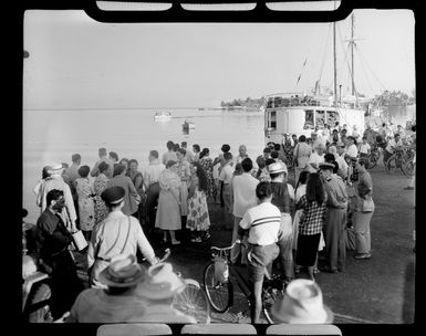 Locals watch from waterfront as TEAL (Tasman Empire Airways Limited) flying boat departs Tahiti, showing boats in the harbour