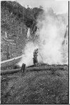 Gardening: woman tends burning of plant debris