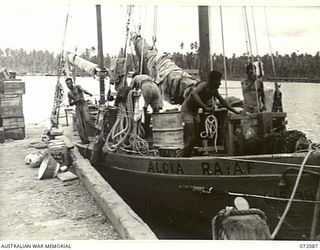 MILNE BAY, NEW GUINEA. 1944-04-06. NEW GUINEA NATIVES UNLOAD THE "ALCIA" A ROYAL AUSTRALIAN AIR FORCE SMALL CRAFT