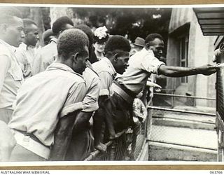 SYDNEY, NSW. 1944-01-26. AUSTRALIAN AND NEW GUINEA ADMINISTRATION UNIT NATIVES FEEDING THE MARMOSET (SMALL MONKEY) AT THE TARONGA PARK ZOO