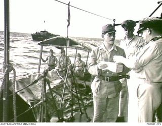 THE SOLOMON ISLANDS, 1945-O8-19. A NAVAL OFFICER ON BOARD HMAS LITHGOW HOLDING TALKS WITH AN ENVOY OF LIEUTENANT GENERAL MASATANE KANDA, COMMANDER JAPANESE XVII ARMY, OFF MOILA POINT, BOUGAINVILLE ..