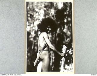 1942-08-06. PAPUA. WILD AND FORMIDABLE AS HE LOOKS IN NATURE'S GARB AND WITH HIS HUGE KNIFE, THIS BOY "HARRY" IS IN FACT A FRIENDLY SOUL AND SPEAKS PRECISE ENGLISH. THE AID OF THIS NATIVE IS ..
