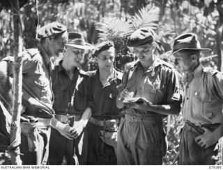 KAMANDRAN, NEW BRITAIN. 1945-02-19. OFFICERS OF B COMPANY, 1ST NEW GUINEA INFANTRY BATTALION CHECKING A MAP OF THE AREA WHILE DISCUSSING THEIR NEXT OPERATION. THEY ARE:- NX156125 WARRANT OFFICER ..